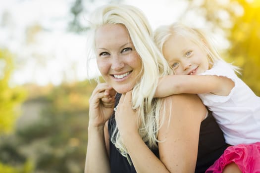 Pretty Mother and Little Girl Having Fun Together in the Grass.