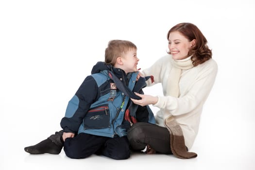 Young women and boy in winter clothing on isolated studio background