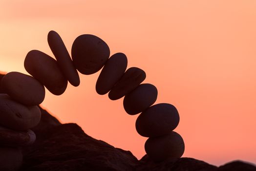 Curve of pebbles in the form of a arch on the coast