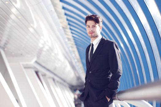 Young Businessman standing in corridor of modern office building