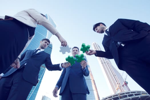 Photo of businesspeople holding jigsaw puzzle outdoors