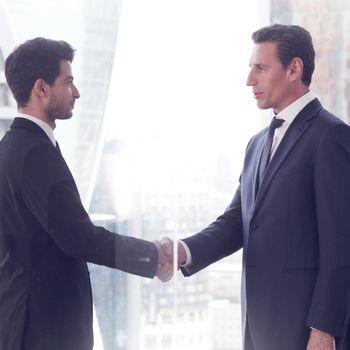 Business people shaking hands, finishing up a meeting in office