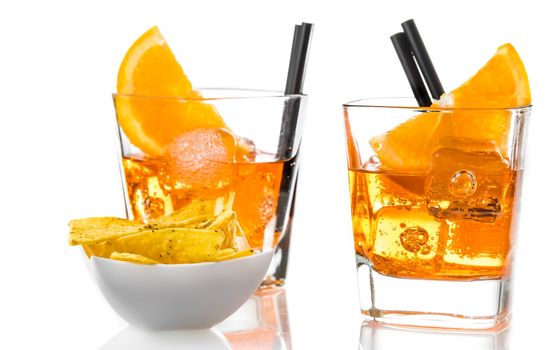 glasses of spritz aperitif aperol cocktail with orange slices and ice cubes near tacos chips on white background