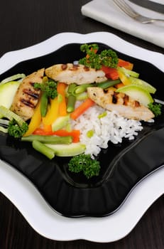 Rice with slices of chicken breast and vegetables