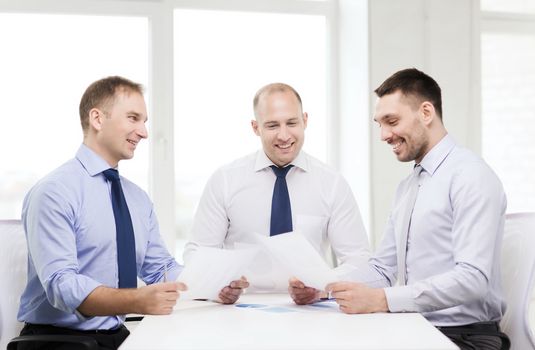 business and office concept - smiling businessmen with papers in office