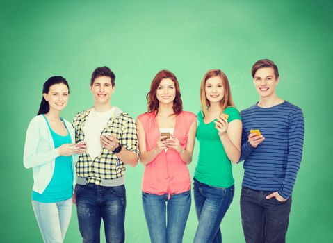 education and modern technology concept - smiling students with smartphones