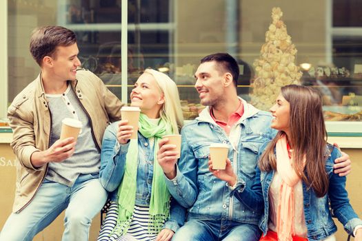 friendship, travel, drink and vacation concept - group of smiling friends with take away coffee