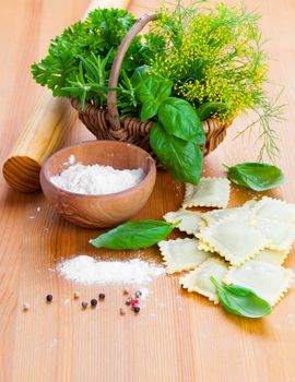 Raw ravioli with flour on wooden table