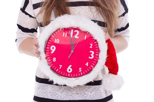 Big clocks in a Christmas hat in female hands. New Year. 12 hours