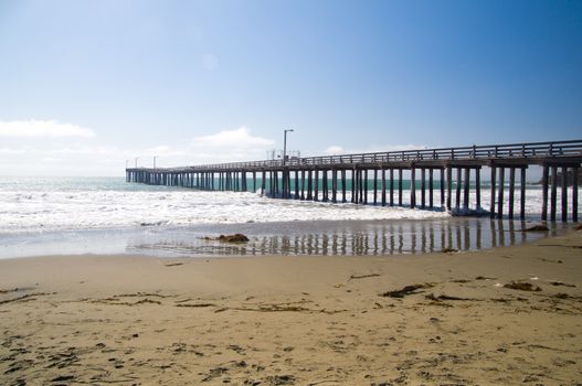 Pier on deserted beach California Coast