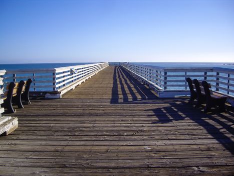 Long pier with two benches at coast