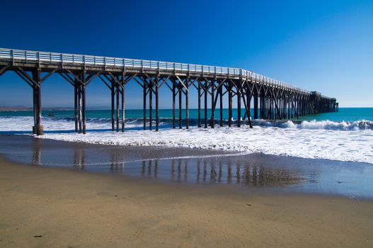 Pier winds into Pacific Ocean at California coast