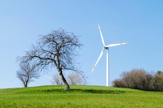 single wind turbine on the hill produces green clean energy