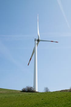 single wind turbine on the hill produces green clean energy