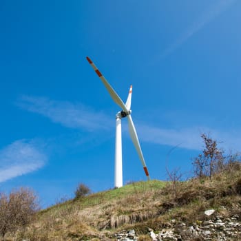 single wind turbine on the hill produces green clean energy