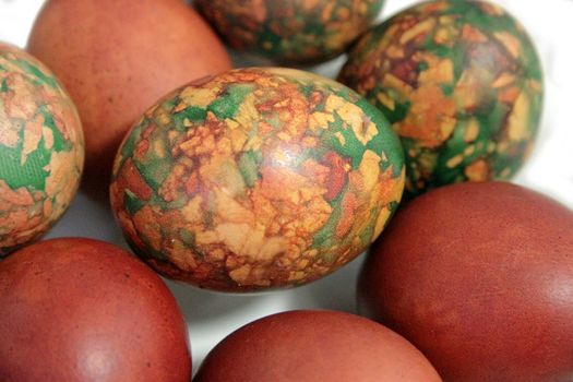 Colorful Easter eggs on white plate placed