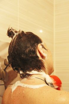 Adult woman washing her hair in the shower