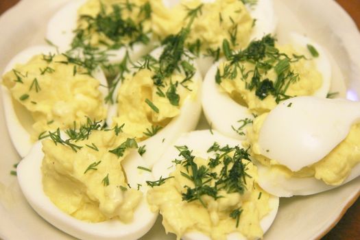 Boiled eggs sliced in halves stuffed and filling by pasta with dill