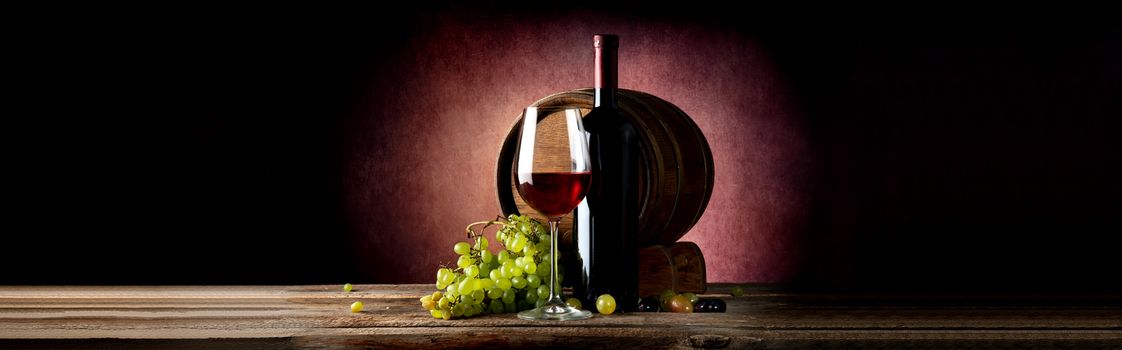 Wine and wooden cask on table and vinous background