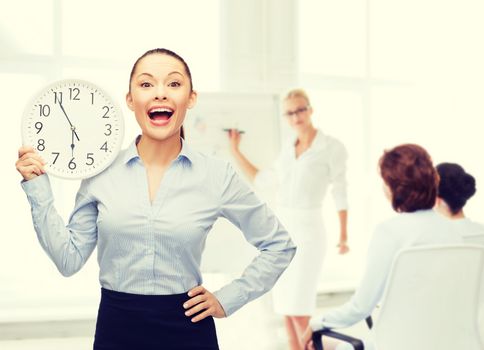 business and time concept - attractive businesswoman with wall clock