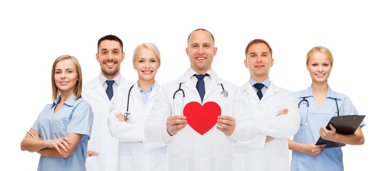 medicine, profession, teamwork and healthcare concept - group of smiling medics or doctors holding red paper heart shape, clipboard and stethoscopes over white background