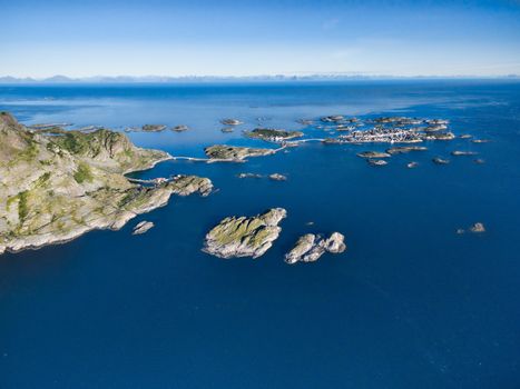 Aerial view of picturesque fishing port Henningsvaer on small islands in the sea and road bridges leading to it