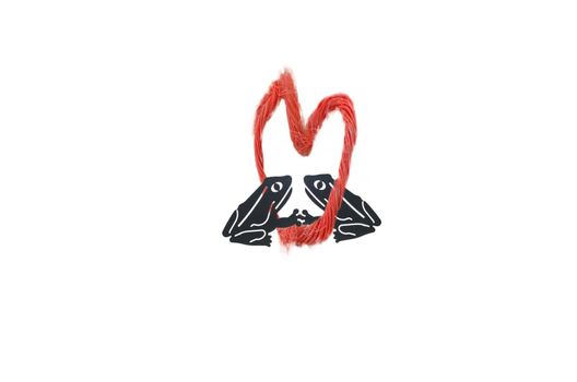 Red rope in heart shape,
right and left of the heart ever a frog kissing each other