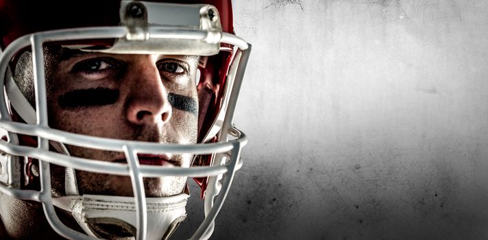 American football player looking at camera against grey background