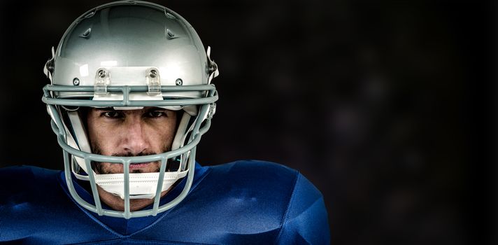 Portrait of American football player against black background