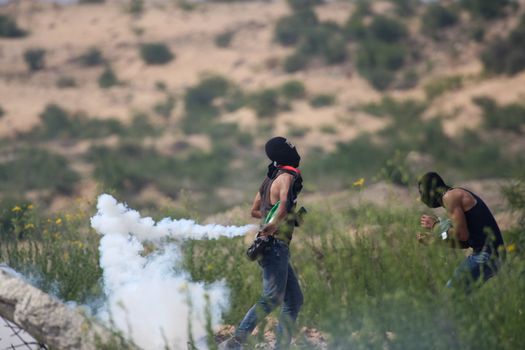 PALESTINE, Gaza Strip: A Palestinian protesters throws a can of tear gas near the Erez crossing between Israel and the Gaza Strip as protesters battled with Israeli security forces on October 13, 2015.As a wave of stabbings hit Jerusalem, violent protests flared up in the West Bank. The unrest has lead to warnings that a full-scale Palestinian uprising, or Intifada, could erupt. The unrest has also spread to the Gaza Strip, with fighting along the border in recent days leaving nine Palestinians dead. 