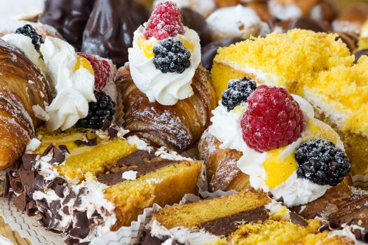 In the pictured typical italian pastries with cream,choccolate,rasperry and blackberry with various forms.