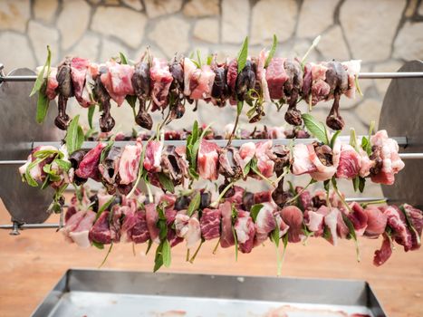 birds on the spit with meat, bacon and sage ready for roasting