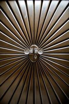 Metal door shaped sunburst with round handles.