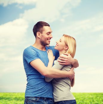 love and family concept - smiling couple hugging and looking at each other