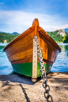 Detail of Anchored Wooden Tourist Boat on Shore of Bled Lake, Slovenia with Bled Castle in Background