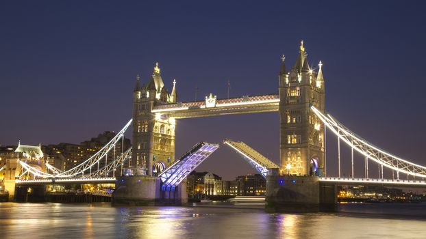 Tower bridge raised at night, London, UK