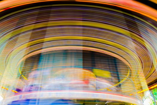 Motion blurr of vintage merry-go-round carousel.