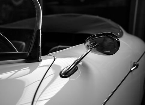 Chrome rearview mirror of a white sports car