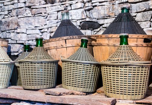 Demijohns of wine in a stone cellar.