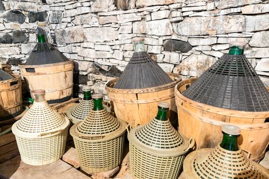 Demijohns of wine in a stone cellar.