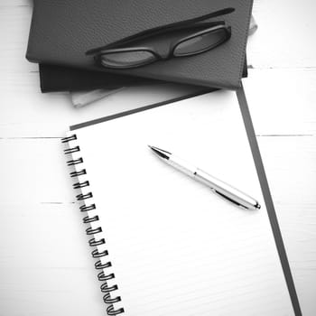 notepad with stack of book on table view from above black and white tone color style