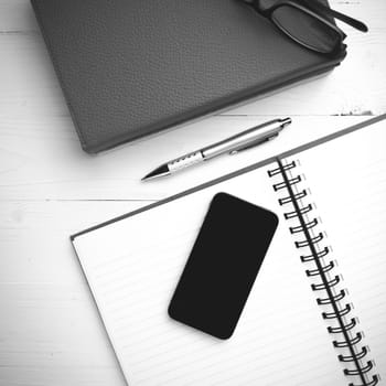 notepad with stack of book on table view from above black and white tone color style