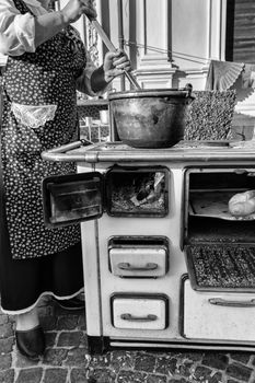 Cooking polenta in a copper pot on wood stove (dish of the Venetian tradition, Italy).