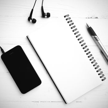 notepad and cellphone over white table black and white color tone style