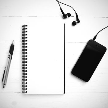 notepad and cellphone over white table black and white color tone style