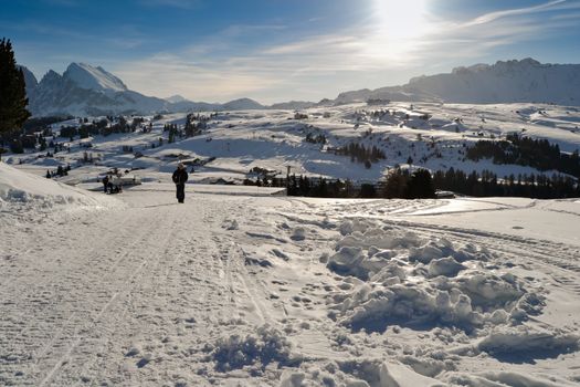 ORTISEI, ITALY - CIRCA DECEMBER 2012: People walks on ski slopes covered with snow on the Italian Alps.