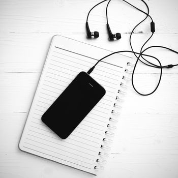 notepad and cellphone over white table black and white color tone style