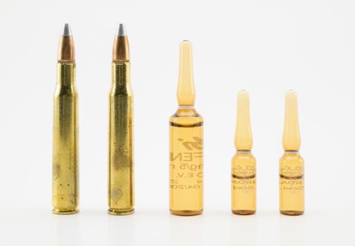 composition with vials and bullets on white background