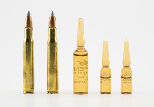 composition with vials and bullets on white background