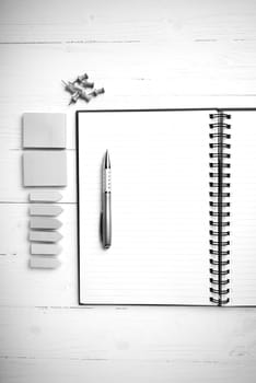 notepad with office supplies on white table view from above black and white tone color style